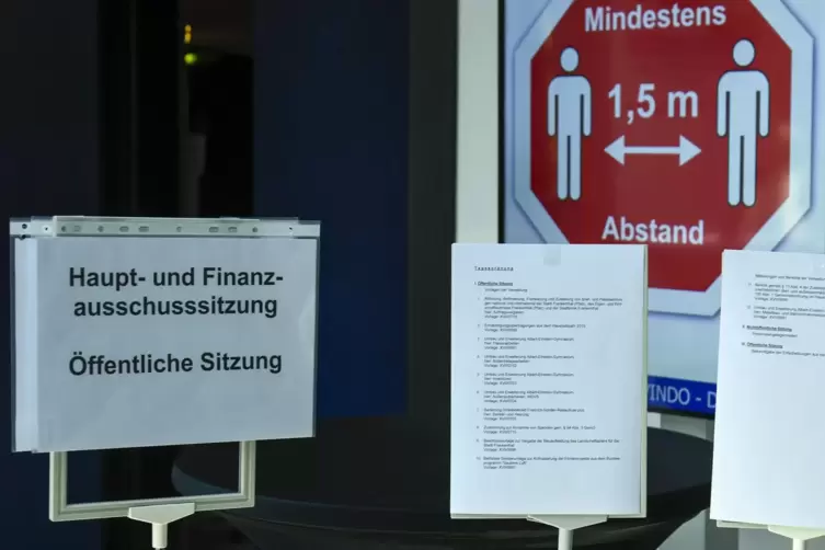 Schon im Foyer weisen hinter der Tagesordnung Schilder auf den Mindestabstand von anderthalb Metern hin.