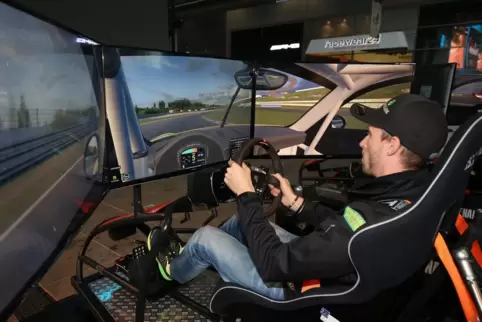 Beim Simracing fährt man mit einem Lenkrad und Pedalen in Rennschalensitzen vor einem Monitor.
