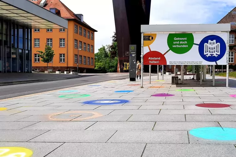 Am Boden vor der Bushaltestelle sollen bunte Kreise den Studenten dabei helfen, den richtigen Abstand einzuhalten. 