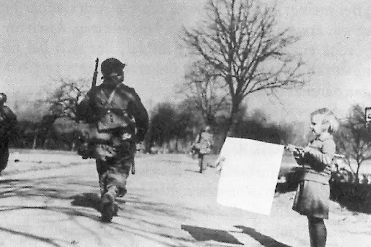 US-Soldaten auf dem Weg nach Neuhofen. Das &auml;dchen mit der wei&szlig;en Fahne istChrista Merdenz, geborene Trenkle.