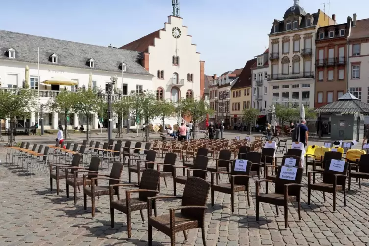 Die leeren Stühle symbolisieren die fehlenden Gäste. 