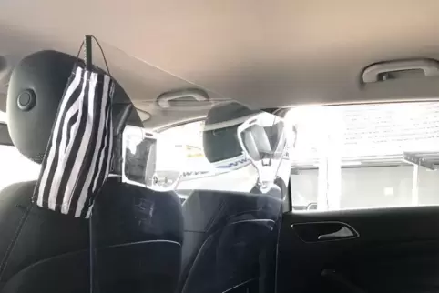 Taxi-Ausstattung in Corona-Zeiten: Eine Plexigalsscheibe trennt den Fahrer vom Fahrgast. Desinfektionsmittel liegen bereit. 