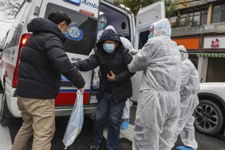  In Wuhan nahm die Corona-Pandemie ihren Anfang. Krankenhausmitarbeiter in Schutzkleidung helfen einem Patienten aus einem Krank