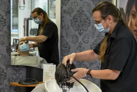 Die Haarwäsche vor dem Schneiden ist derzeit obligatorisch: Friseurmeister Guy Alexander Gering mit seinem Kunden Sasan Mavadat.