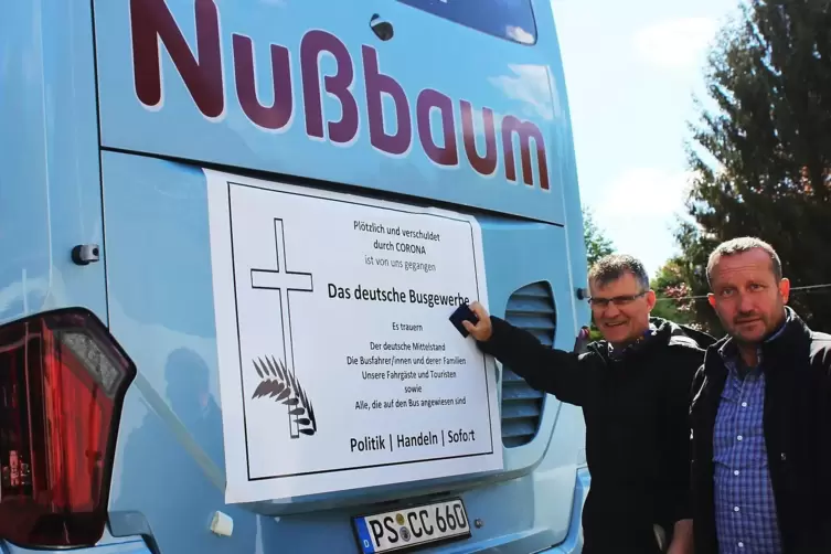 Markus Fuchs (rechts) und Thiemo Sauer (Firma Komet) haben den Berlin-Bus mit einer „Todesanzeige“ beklebt.