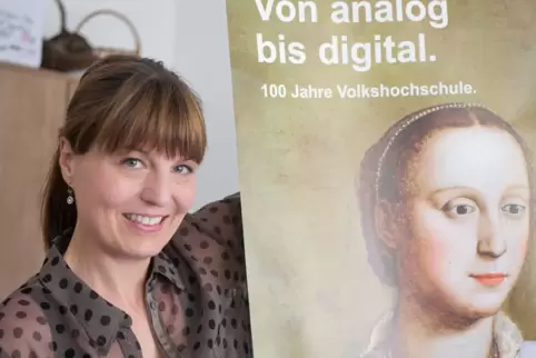 Alexandra Matern und ein Plakat zum 100. Jubiläum der Volkshochschulen im Jahr 2019: Dass sich die Frage „analog oder digital“ i