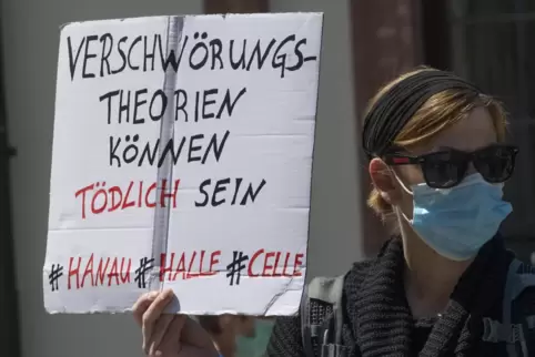 Gegendemonstration: Eine Frau warnt vor Verschwörungstheorien.