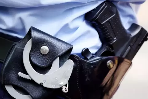 Ein Polizist mit Handschellen und Pistole am Gürtel .