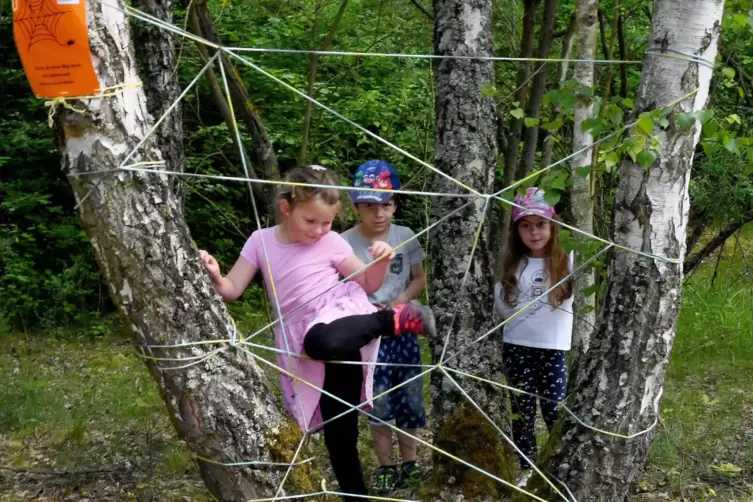 Melina, Leo und Alessia (von links) klettern begeistert durch das Spinnennetz des Mitmachpfades.