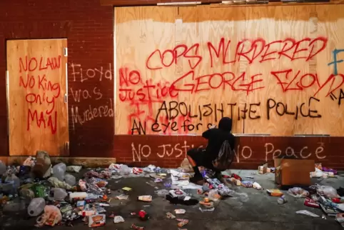 „Floyd wurde ermordet“: Ein Demonstrant sprüht Graffiti auf eine Bretterwand in der Nähe eines Polizeireviers von Minneapolis. 