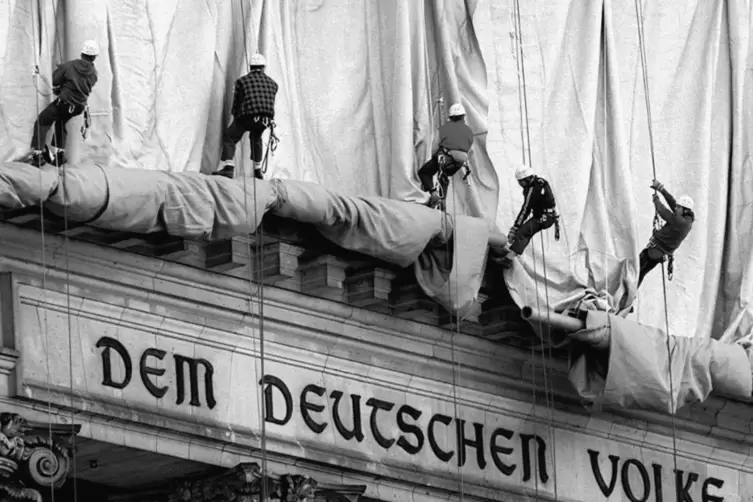 Sommer 1995: Kletterer rollen die Verh&uuml;llungsplanen f&uuml;r den Berliner Reichstag ab.