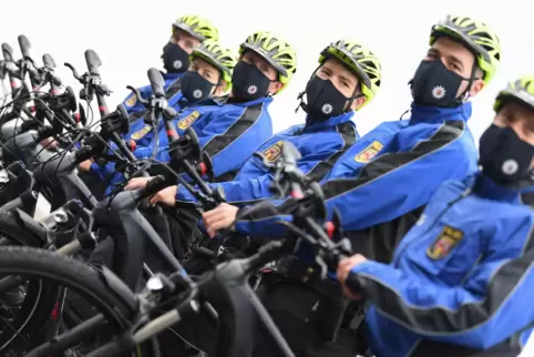 Polizeibeamte stehen beim Start eines Pilotprojekts zum Einsatz von Elektro-Fahrrädern an ihren Pedelecs. 