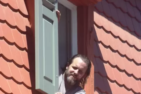 Bauherr Dirk Eichberger mit den gerade eingesetzten renovierten Klappläden.