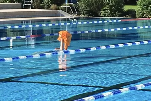 Diese Schwimmerin hat ihre Sachen an der falschen Beckenseite abgelegt und transportiert sie schwimmend zur richtigen Seite.