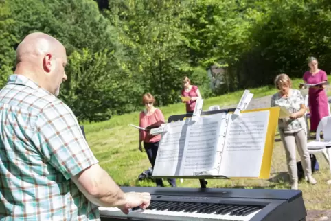 Chorleiter Wolf-Rüdiger Schreiweis (links) gibt bei der Probe von Gospel & Praise auf dem Parkplatz des Sängerbundes in Contwig 