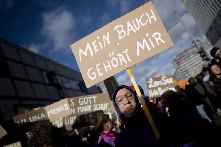  Eine Demonstrantin mit Plakat auf einer Kundgebung zum Internationalen Frauentag. 