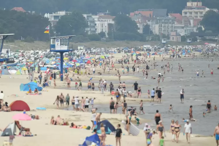 Touristen nutzen am Sonntag das hochsommerliche Wetter am Strand auf der Insel Usedom zum Sonnen und Baden. 