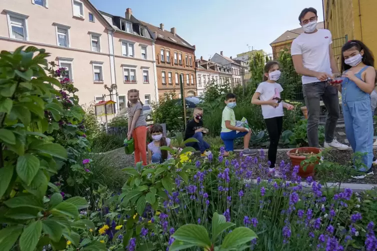 Haben Freude bei der Gartenarbeit: Florian Brill, Klassenlehrer der 3b, mit Schülerinnen und Schülern. 
