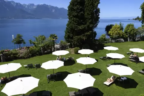 Am Ufer des Genfersees: Menschen entspannen sich unter Sonnenschirmen – mit Abstand. 