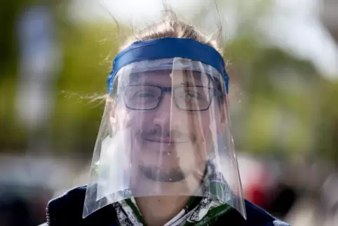 Immer häufiger zu sehen: Gesichtsvisiere sollen vor einer Ansteckung schützen. 