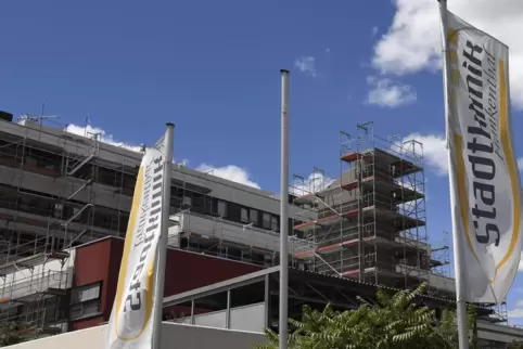 Stürmische Zeiten: Fahnen der Stadtklinik vor dem eingerüsteten Hauptgebäude des kommunalen Krankenhauses.