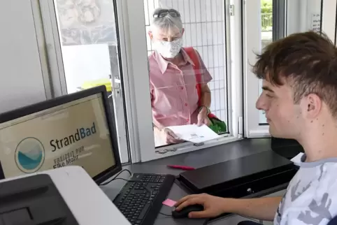 Eintrittskarte gegen Bares: Stadtwerke-Mitarbeiter Muhammed Akdeniz versorgt Elke Mohr an der Kasse mit einem Ticket fürs Strand