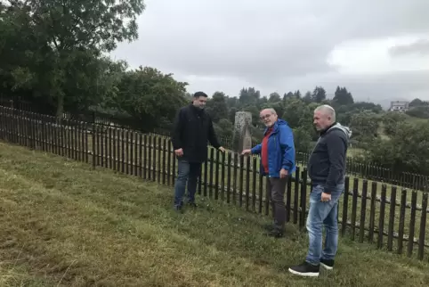 Ortsbürgermeister Torsten Windecker, Eberhard Dittus und Slava Nechitajlo inspizieren die Umzäunung des jüdischen Friedhofs. 