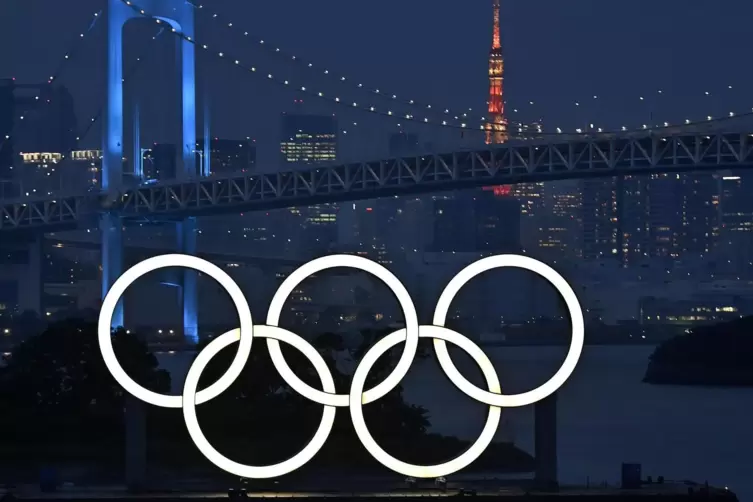 Ein Monument mit der Darstellung der Olympischen Ringe leuchtet im Hafenviertel Odaiba in Tokio.