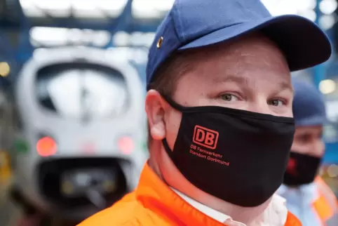 Masken und Abstand bleiben Pflicht - hier bei einem Bahn-Mitarbeiter.