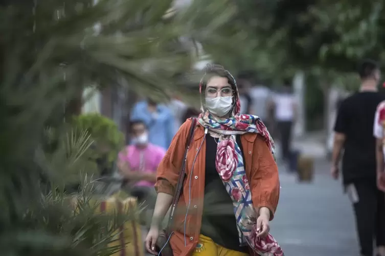 Besorgniserregende Lage: Eine Frau trägt beim Spazieren in Teheran einen Mundschutz gegen das Coronavirus. 