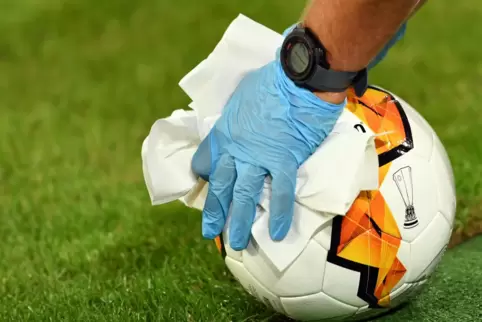 Ungewohnte Handschuhe am Ball: Das runde Leder zu desinfizieren, ist nicht schwer. Die Überwachung anderer Hygieneregeln wegen d