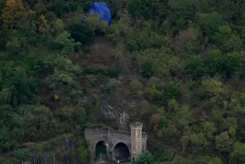 Die Hülle eines Heißluftballons hängt nach einem Unfall am Sonntagabend im Hang, verfangen in Bäumen, oberhalb des Rheintals bei