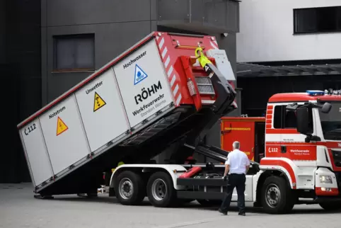 Ein Container mit Geräten und Ausrüstung für ein Hochwasserszenario wird auf ein Spezialfahrzeug einer Werkfeuerwehr geladen.