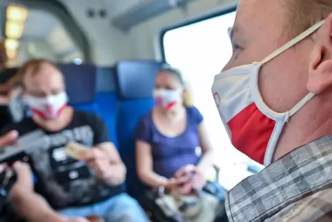 Fahrgäste in einem Regionalzug mit korrekt aufgesetztem Mund-Nasen-Schutz - also über der Nase.