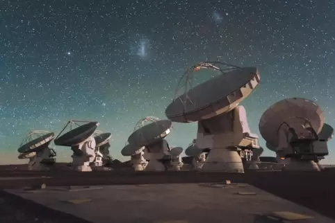 the_atacama_large_millimeter_array_(alma)_by_night,_under_the_magellanic_clouds