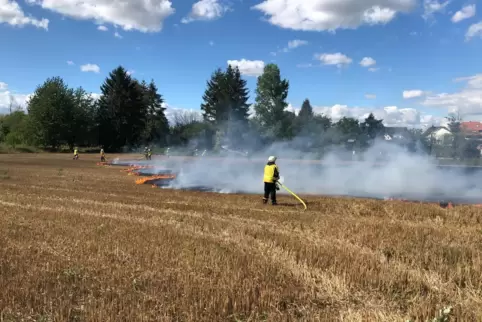 Die Feuerwehr löscht den Brand auf dem Acker nahe der Obergartenstraße in Lingenfeld. 