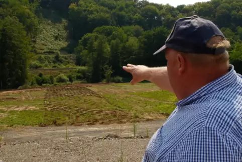 Mit ausgestrecktem Arm zeigt Volker Priebe auf die „kahl rasierte“ Stelle im Hang, wo sich künftig die Öffnung für den Straßentu