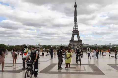 Halten auch alle Abstand? Fahrradpolizisten mit Gesichtsmasken patrouillieren auf der Esplanade Trocadero in der Nähe des Eiffel
