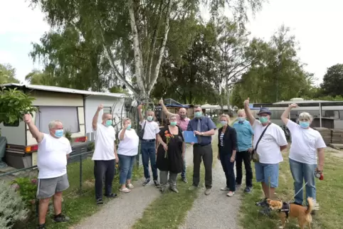 Daumen hoch: Die Camper sind erleichtert, dass Ursula Schmidt, Vorsitzende der „Camping-IG in den Rheinauen“ (Mitte, mit Blumen)