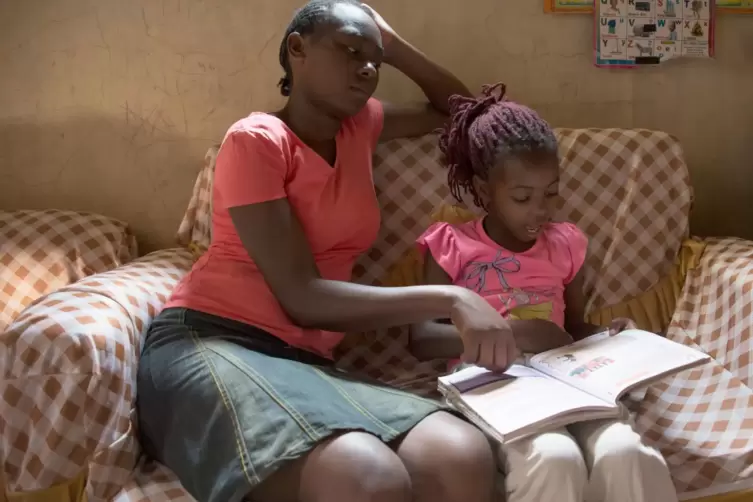 Unterricht in Corona-Zeiten: Die 17-jährige Mary hilft ihrer zehnjährigen Schwester Joy in einem Slum von Nairobi beim Lesen. 