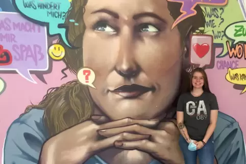 Celina Helgert steht in der Jugendberufsagentur Mainz vor einem Graffiti. 