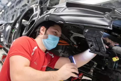 Der Übergang vom Verbrenner- um E-Motor stellt die Autoindustrie von große Herausforderungen. Unser Bild zeigt einen Mitarbeiter