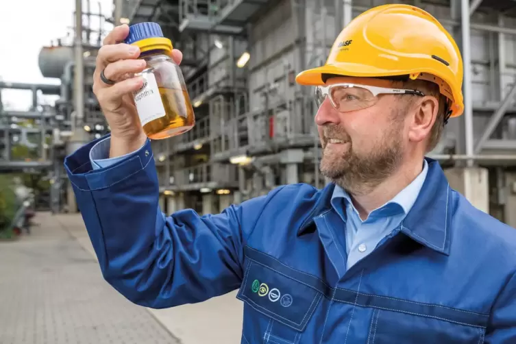 So sieht das Pyrolyse&ouml;l aus: Andreas Kicherer, Nachhaltigkeitsexperte der BASF betrachtet eine Flasche des Rohstoffs. 