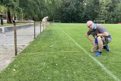 Der SVG-Vorsitzende Ronald Helf misst mit Zollstock nach: Die Linienrichter haben nun mehr als zwei Meter Abstand zu den Zuschau