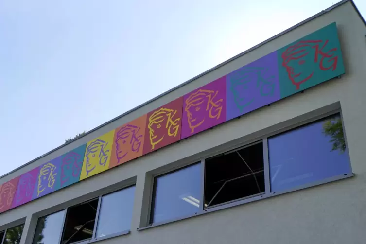 Bunter Blickfang: Zwischen Fensterstreifen und Dachkante ist ein Fries mit dem Logo des Karolinengymnasiums angebracht.