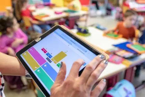 Angestrebt: Eine Lehrerin unterrichtet Grundschüler mit einem Tablet. 
