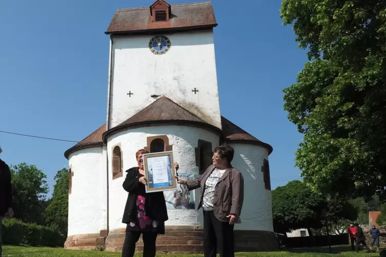 Pfarrerin Ines Weiland-Weiser (links) mit der Urkunde für die „Kirche des Jahres“. Rechts daneben Presbyterin Marliese Rauch.