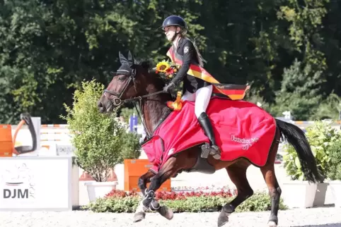 Ab auf die Ehrenrunde: Charlotte Stuppi grüßt mit Asterix als deutsche Meisterin der U14-Springreiter.