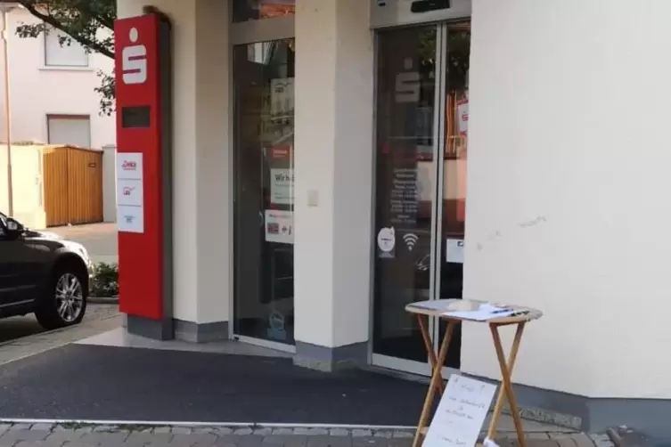 Geschlossen: die Sparkasse in Harthausen. Davor steht ein Tisch mit einer Liste, auf der Unterschriften gesammelt werden. Die Li