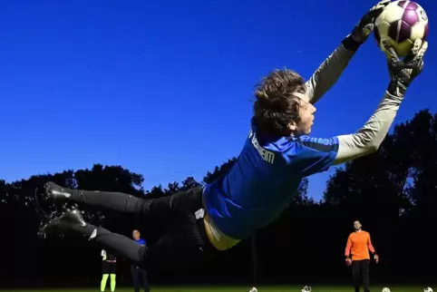 Den Schuss von seinem Torwart-Kollegen Daniel Sauter (in Orange) pariert Geinsheims Keeper Marcel Johann in der Luft.